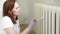 Woman in glove painting heating radiator