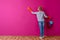 Woman in gloves cleaning color wall