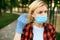 Woman in gloves puts mask on her face, quarantine