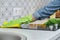 Woman in gloves with rag cleaning kitchen, washing electric hob