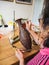 Woman gluing tiny shaped cloisonne wires to a copper vase