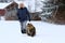 A woman goes for a walk with her Norwegian Forest Cat in winter