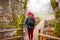 Woman is going across the wooden bridge while hiking