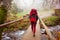 Woman is going across the wooden bridge while hiking