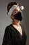 Woman with gold christmas hat, black medical mask. Fashion shiny style for xmas time. Protection from flu on holidays