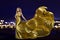Woman in Gold Dress over Night City, Fashion Model in Long Golden Gown, Waving Fabric