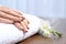 Woman with gold manicure on rolled towel at table. Nail polish trends