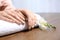 Woman with gold manicure on rolled towel at table. Nail polish trends