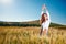 Woman on golden cereal field in summer