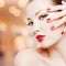 Woman with golden glamour makeup and red manicure