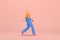 The woman with golden hair tied in a bun wearing blue corduroy pants and Orange T-shirt with white stripes. She is walking. 3d