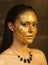 Woman with golden makeup and bodyart