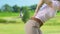 Woman golfer making backswing hitting ball and feeling sharp lower back pain