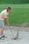 Woman golfer in a sand bunker