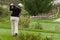 Woman golfer swinging driver on tee box