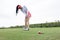 woman golfer teeing golf in golf tournament competition at golf course, selective focus on golf ball