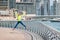 Woman after a good run rejoices at her success and jumps in delight on the Dubai Marina embankment