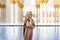 Woman in grand mosque of Sheikh Zayed in front of water. Islamic decor. Female tourist in muslim country.