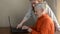 Woman granddaughter teaches her elderly grandmother to use a laptop