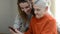 Woman granddaughter teaches her elderly grandmother to use a laptop