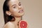 woman grapefruit near face clean skin care health beige background