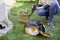 Woman in the grass of her backyard planting flowers in a plant pot with flowerpot earth