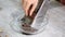 Woman grates chocolate dough in the glass bowl.