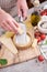 Woman grates Parmesan cheese on a wooden cutting board at domestic kitchen