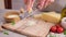 woman grates piece of parmesan hard cheese on a grater at domestic kitchen