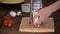 Woman grating cheese on wooden table.