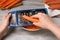 Woman grating fresh carrot at wooden table, closeup