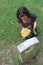 Woman at grave stone with yellow flowers.