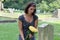 Woman at grave stone with yellow flowers.