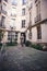 Woman in gray dress standing in courtyard of house of European cities