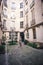 Woman in gray dress standing in courtyard of house of European cities