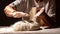 Woman great-grandmother clapping hands to dust a mound of freshly prepared pastry with flour dough for home baking