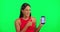 Woman, green screen and point at phone, face and mockup space for logo, branding or review with smile. Girl, model or