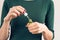 Woman in a green T-shirt and a maroon manicure holding a jar