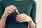 Woman in a green T-shirt and a maroon manicure holding a jar wit