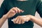 Woman in a green T-shirt and a maroon manicure using hand cream