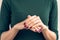 Woman in green T-shirt shows a hands with a maroon manicure