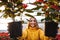 Woman in greenhouse hold poinsettia in pots.