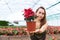 Woman in a greenhouse holds out a pot of poinsettia