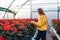 Woman in greenhouse near poinsettia in pots.