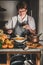 Woman in grey apron cooking and tasting pumpkin soup