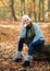 Woman  in grey sweeter and jeans in Autumn park