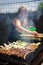 Woman grilling sausages and meat