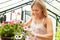 Woman Growing Plants In Greenhouse