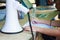 Woman guide hand writing on document paper next to white megaphone on table, preparing permits for group of tourists trips.