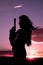 Woman gun hair blowing sunset